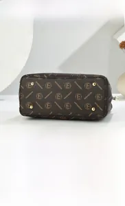 Detail view of the brown monogram tote bag base with golden protective metal feet