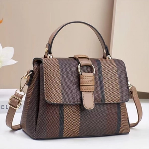Kontrast-Handtasche mit brauner Textur und Goldschnalle, präsentiert mit Schultergurt