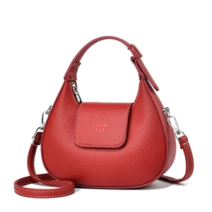 Close-up of crescent moon bag in red leather with fine stitching and silver hardware