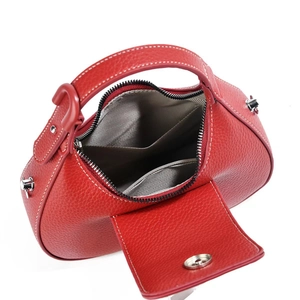 Detail view of red lychee leather handbag showing herringbone lining and internal pocket