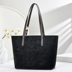 Detail of black tote bag featuring a decorative silk scarf and contrast stitching handle