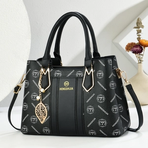 Fashionable black pebbled leather tote bag with logo pattern and pearl charm accessory