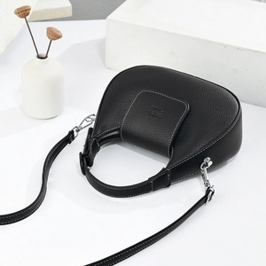 Close-up of black lychee grain leather hobo bag with white stitching and silver hardware
