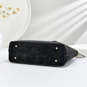 Detail view of large tote bag bottom with protective gold studs and matte texture
