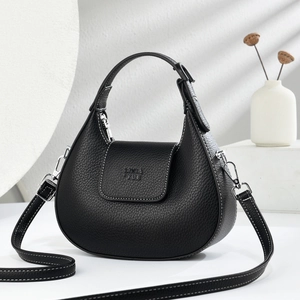 Close-up of black lychee grain leather hobo bag with silver hardware and logo detail