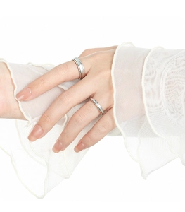 Bagues de couple minimalistes en argent mat portées avec des détails en tulle élégants