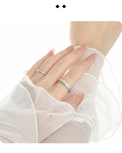 Gros plan sur des bagues en argent mat minimalistes sur des gants en dentelle élégants