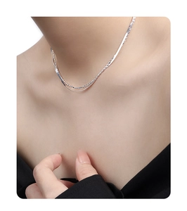 Gros plan d'un collier double épaisseur en argent sterling S925 sur le cou d'une femme
