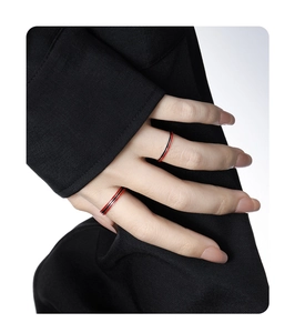 Close-up of minimalist enamel stackable rings in red, white and black striped patterns