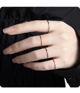 Close-up of four minimalist S925 sterling silver rings including red enamel thin bands