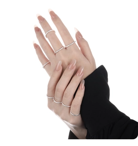 Anelli sottili in argento sovrapponibili indossati da modella con finitura in metallo lucido