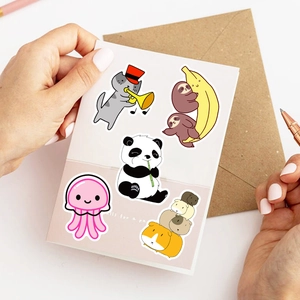 Close-up of cute animal stickers featuring a cat, panda, and sloth on white cards