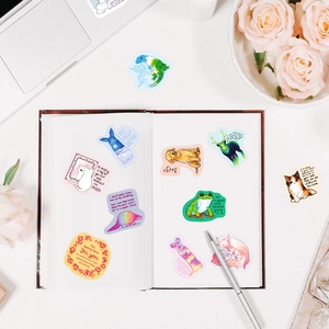 Flat lay of hand-drawn animal stickers with inspirational quotes on white desk