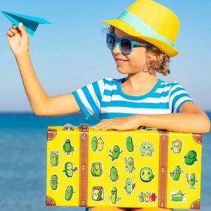 Cute green pickle stickers featuring various funny characters on a vintage yellow suitcase