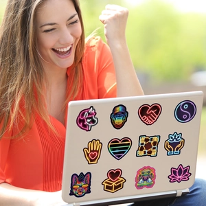 Neon style decorative stickers on a laptop used by a woman in bright sunlight