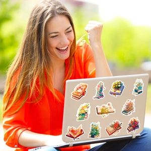 Dettaglio di adesivi vintage con fiori e libri su un laptop in un ambiente esterno