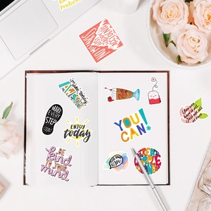 Gros plan de stickers de papeterie inspirants sur un bureau blanc pour décor DIY