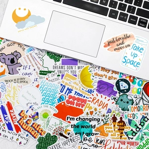 Vue à plat d'autocollants colorés avec phrases inspirantes sur un ordinateur portable