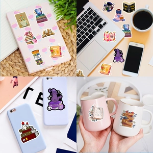 Close-up of decorative bookish stickers applied on laptop, phone case, and notebook