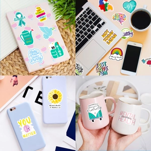 Detail of mental health stickers applied on laptops and mugs with positive quotes