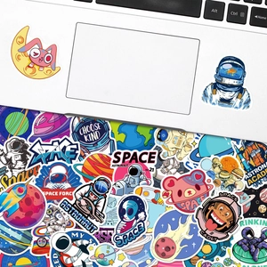 Detailed view of astronaut and space stickers applied on a laptop and scattered below