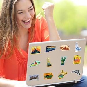 Laptop decorato all'aperto con adesivi colorati di viaggio e mappe degli stati USA