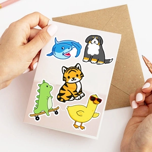 Close-up of cute waterproof animal stickers on white card with a kraft envelope
