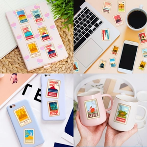 Detailed view of vintage world landmark postage stamp stickers on a laptop and water bottle