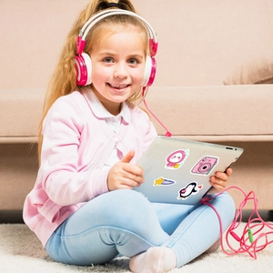 Waterproof camera stickers applied to a tablet used by a girl in a cozy home setting