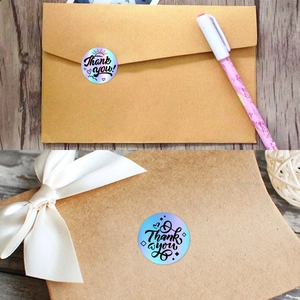 Holographic Thank You stickers applied to kraft envelopes and white ribbon gift boxes
