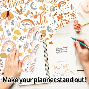 Close-up of Boho rainbow stickers and floral paper on a planner with colorful art supplies