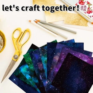 Flat lay of galaxy galaxy patterned DIY craft paper set with crafting accessories