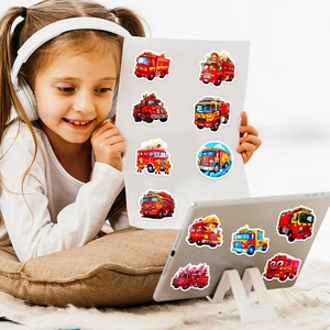 Little girl applying colorful cartoon fire truck stickers on a tablet in a cozy room