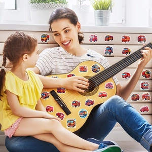 Child and mother applying waterproof cartoon fire truck stickers to furniture for decoration