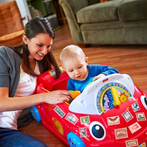Close-up of vintage stamp stickers applied to a red children's toy car learning dashboard