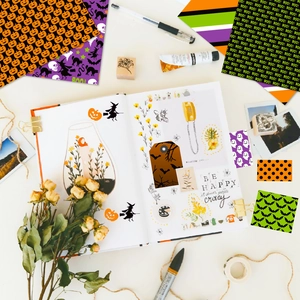 Flat lay of Halloween scrapbooking paper kit with pumpkins, ghosts and witch motifs