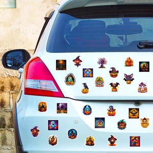 Close-up of colorful Halloween pumpkin and ghost stickers applied on a white car rear