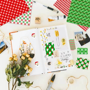 Flat lay of Christmas DIY scrapbooking paper kit with festive patterns and stickers