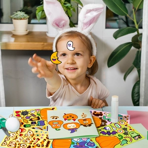 Detail of a child playing with DIY pumpkin face stickers for Halloween party decorations
