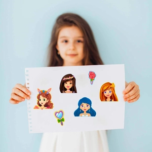 DIY cartoon princess dress-up stickers shown on hand-held paper with various girl characters