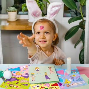 Toddler playing with pink princess make-a-face stickers and dress-up puzzles for girls