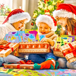 Happy children in Christmas hats unboxing pink princess DIY make-a-face sticker sets