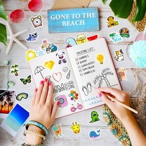 Détail d'autocollants d'été sur une page de journal avec des accessoires de plage
