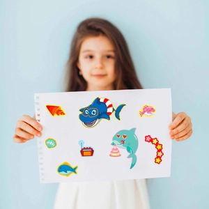 Detail of DIY shark puzzle stickers with colorful sea creatures held by a child