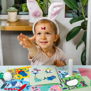 Close-up of child applying colorful DIY shark face-changing stickers at home