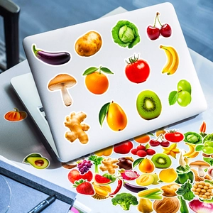 Realistische Obst- und Gemüsesticker auf einem silbernen Laptop und grauem Schreibtisch