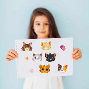 Close-up of cute cartoon cat stickers with various expressions on a white paper