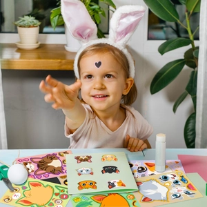 Child creatively using colorful cat face emoji stickers for DIY puzzle projects