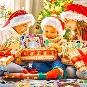 Three happy children with Christmas hats showing colorful DIY cat stickers gift box