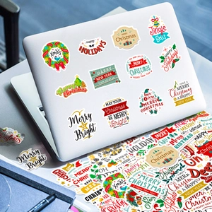 Détail d'autocollants de Noël colorés appliqués sur le couvercle d'un ordinateur blanc
